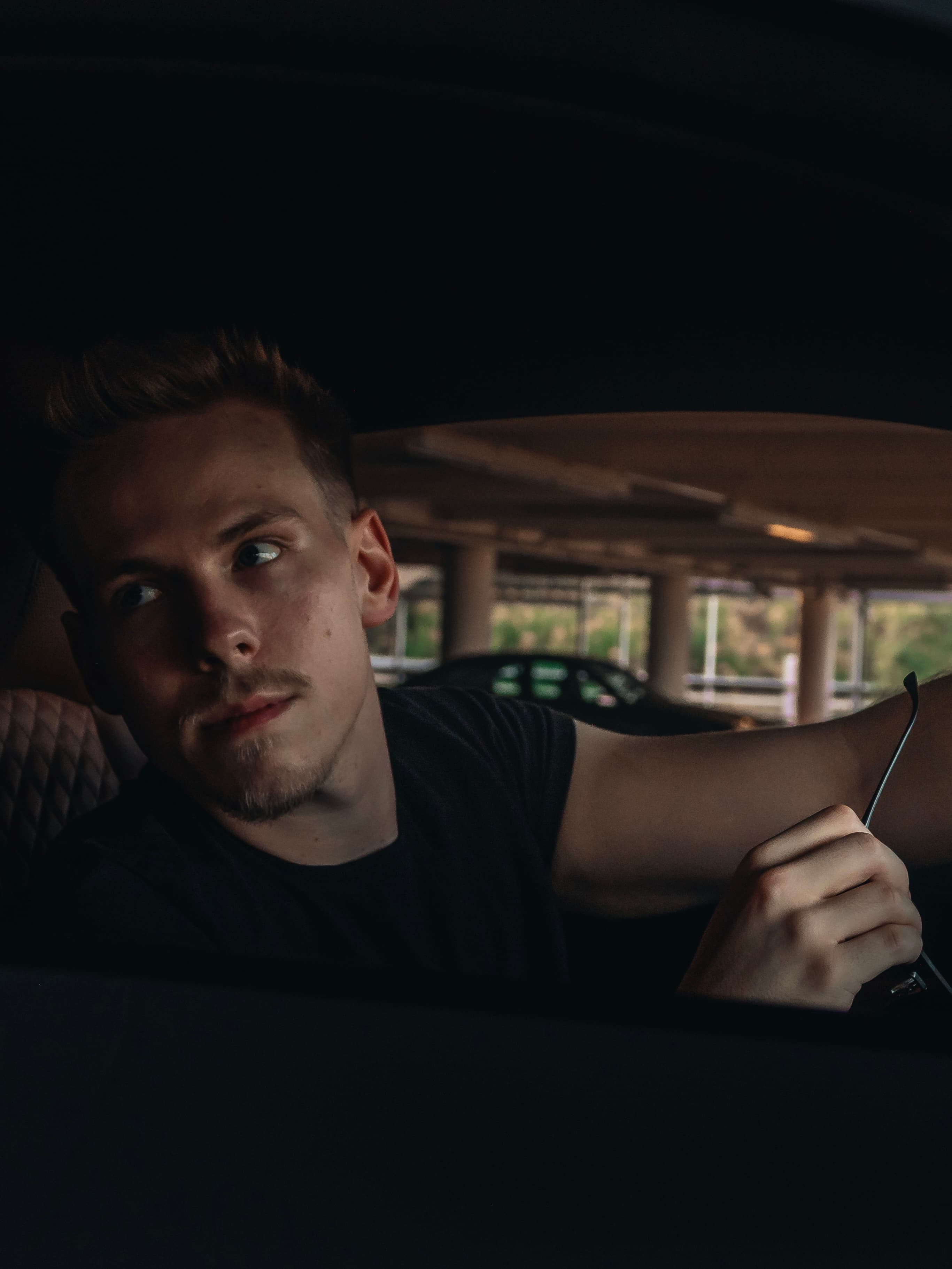 Julian, sitzend im Auto, Blick nach draußen